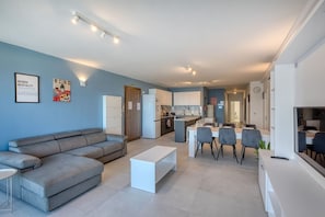 Een modern appartement met een woonkamer, een eetgedeelte, een kitchenette en een kleine keuken.