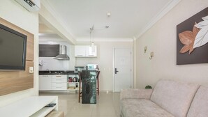 A modern kitchen with white cabinets, a stainless steel range hood, and a dining area with a marble table. - Beautiful Apt in a Cond. With Heated Pools Sbh0233 (Bombinhas)