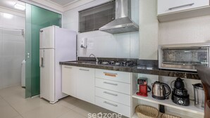A kitchen with a refrigerator, stove, microwave, and various appliances. - Beautiful Apt in a Cond. With Heated Pools Sbh0233 (Bombinhas)