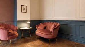 A room with two pink armchairs, a small table, and a lamp. - Old Town Elegant Apartment in Anguillara (Anguillara Sabazia)