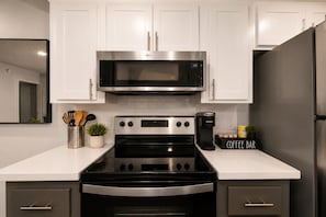 A modern kitchen with stainless steel appliances, white cabinetry, and a coffee bar. - Modern Tempe Retreat Near ASU Pool, Gym, Pet-Friendly, Parking (Tempe)