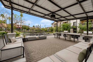 An outdoor patio with a covered seating area, a grill, and potted plants. - Modern Tempe Retreat Near ASU Pool, Gym, Pet-Friendly, Parking (Tempe)