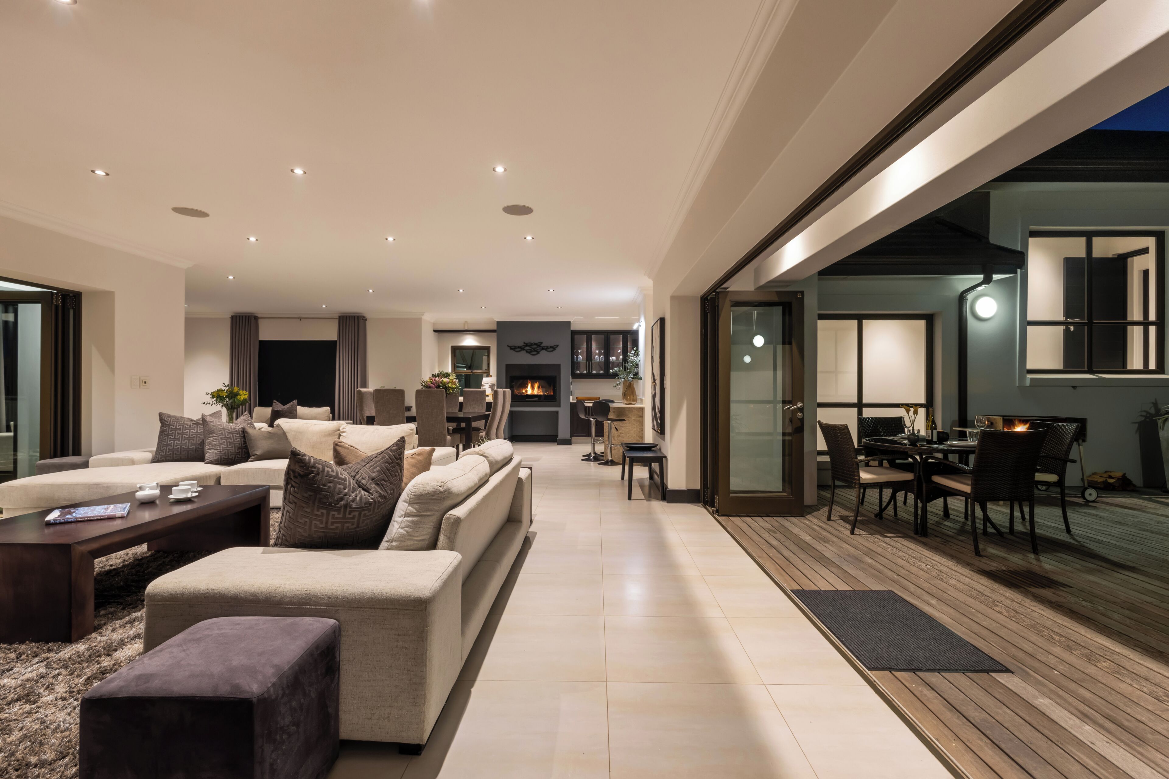 Een moderne woonkamer met een open haard, een eethoek en uitzicht op de omgeving.