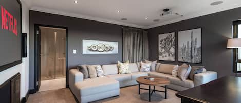 A modern living room with a sectional sofa, a coffee table, and artwork on the walls.