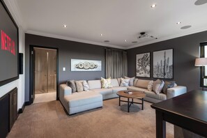Un salon moderne avec un canapé d’angle, une table basse et des œuvres d’art accrochées aux murs.