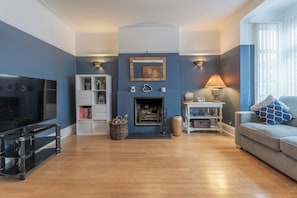 A modern living room with a fireplace, a television, and a sofa.