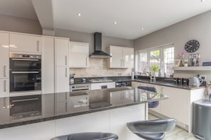 A modern kitchen with a central island, stainless steel appliances, and a large window providing natural light.