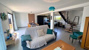 Ein modernes Wohnzimmer mit einer Couch, einem Couchtisch und einer Treppe, die in einen oberen Bereich führt.