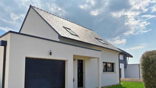 Ein modernes, zweistöckiges Haus mit Satteldach, Garage und kleinem Vorgarten.