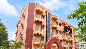 A multi-story building with balconies, a gated entrance, and a sign indicating it is a serviced collection property. - Classic Hotel Bidisha (Kanthi)