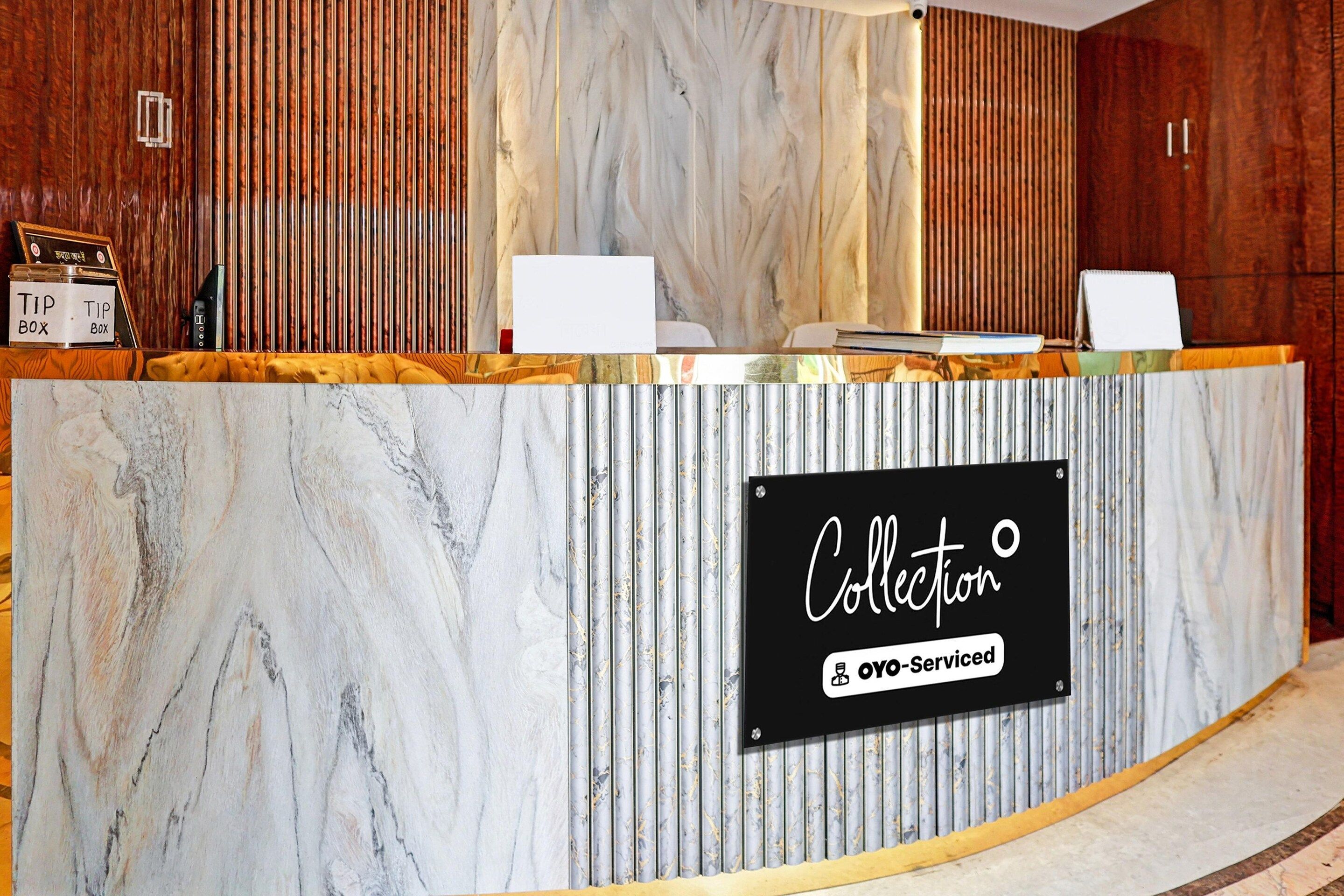 A reception desk with a marble finish and a sign indicating it is a self-service collection point.