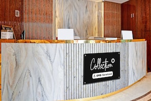 A reception desk with a marble finish and a sign indicating it is a self-service collection point. - Classic Hotel Bidisha (Kanthi)