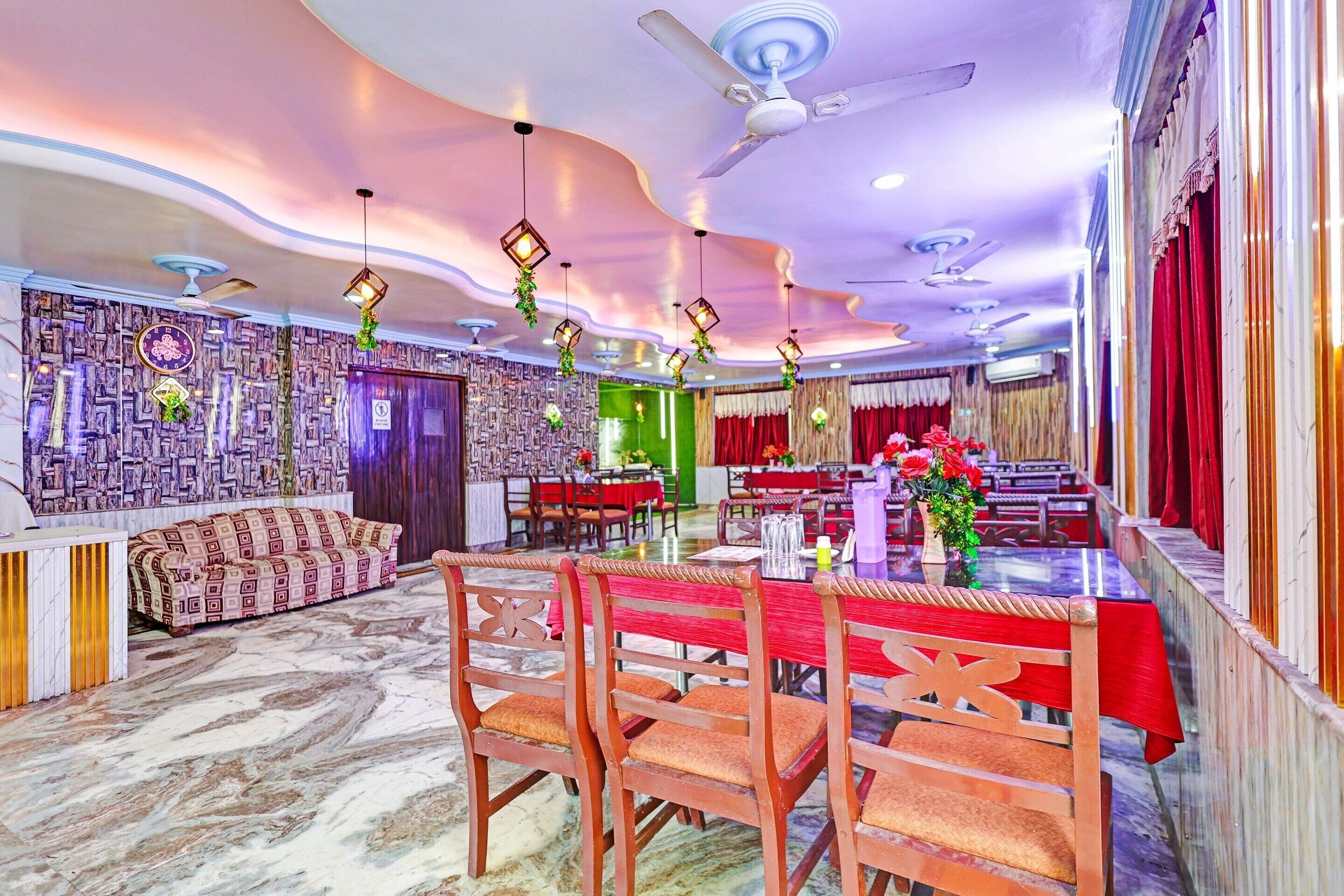Un comedor con techos altos, paredes con diseño y una disposición de mesas y sillas.