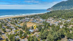 A coastal residential area with houses, a beach, and a forested hillside. - Pelican Perch by Manzanita Beach Getaway- Walk to Beach & Downtown, Dog-Friendly (Manzanita)