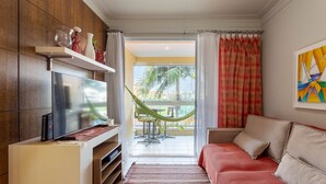 A modern living room with a TV, a hammock, and a sofa. - Comfortable Beachside Apartment in Floripa Rvg101 (Florianópolis)