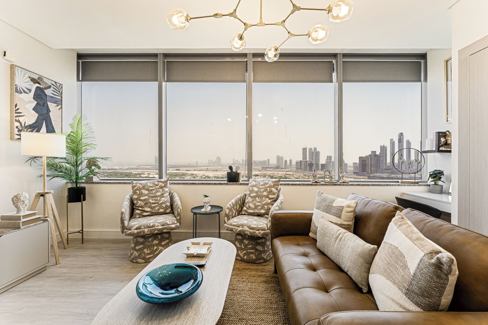 Ein modernes Wohnzimmer mit Blick auf die Stadt, inklusive Sofa, Sesseln, Couchtisch und Stehlampe.