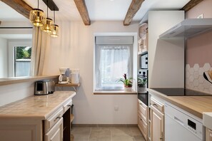 Cocina compacta con ventana, tostadora, cafetera y estufa.