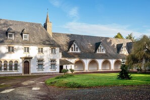 Un edificio histórico con un patio central, arcos y una torre destacada.