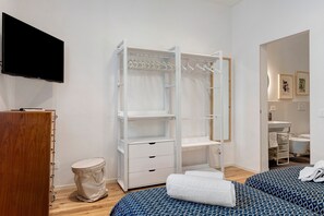 A bedroom with a bed, a wardrobe, a television, and a bathroom. - Spazio Beccaria with Private Garden - Florence (Florence)