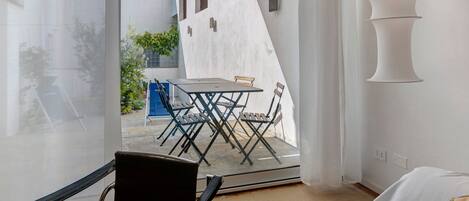 A modern interior with a glass door leading to an outdoor seating area.