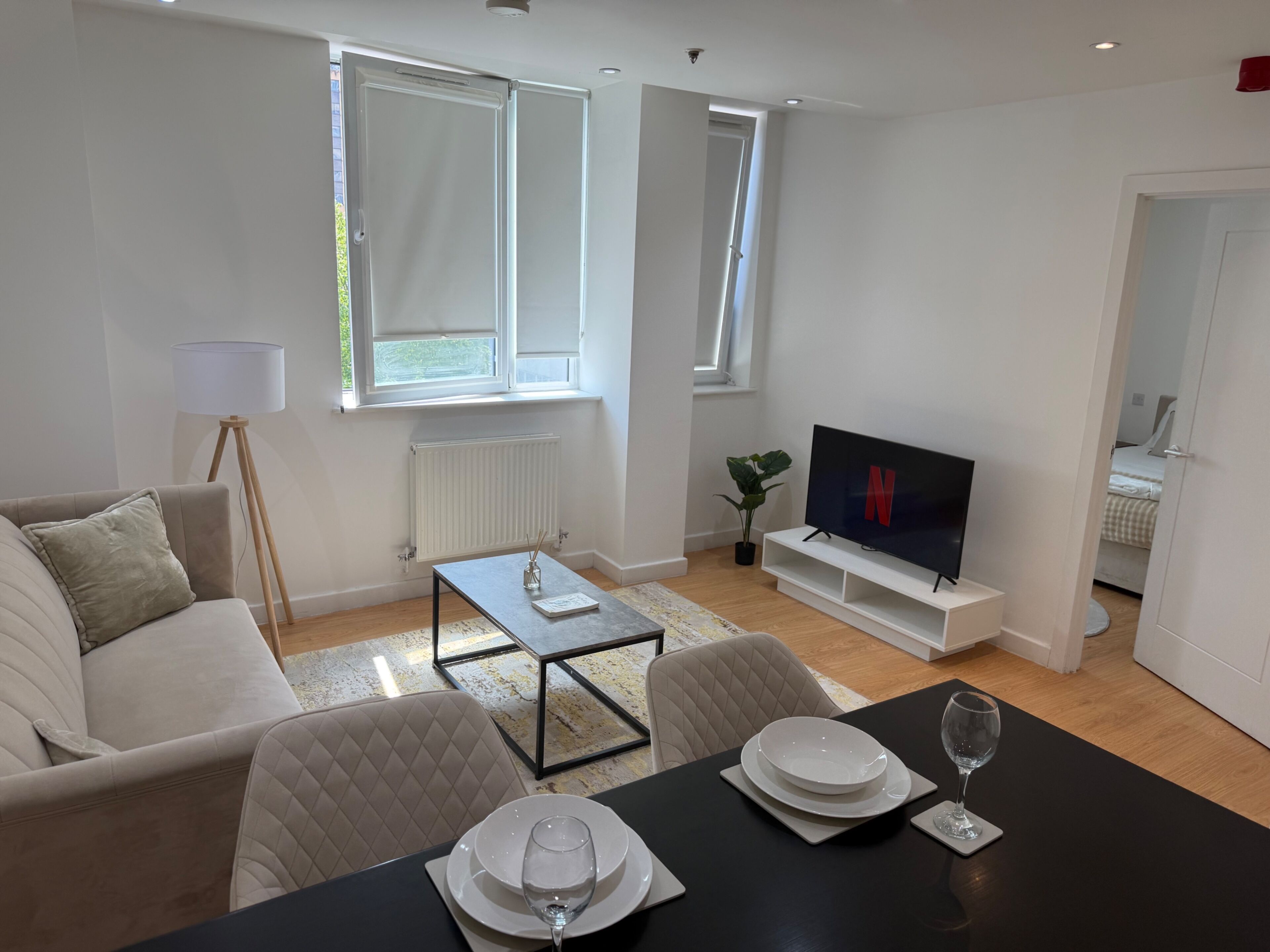 Un salon moderne comprenant un canapé, une table basse, un téléviseur et un coin repas aménagé pour prendre un repas.