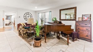 A spacious living room with a grand piano, a dining area, and a large mirror. - Buck Street - Houston (Houston)