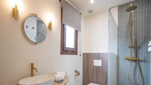 Ein modernes Badezimmer mit einer freistehenden Badewanne, einem Waschbecken mit Spiegel und einer Toilette.