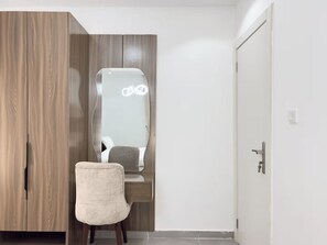 A room with a wooden wardrobe, a mirror, a chair, and a door. - Chic 1-Bedroom in Victoria Island with Pool, Fast Wi-Fi & 24/7 Power (Lagos)