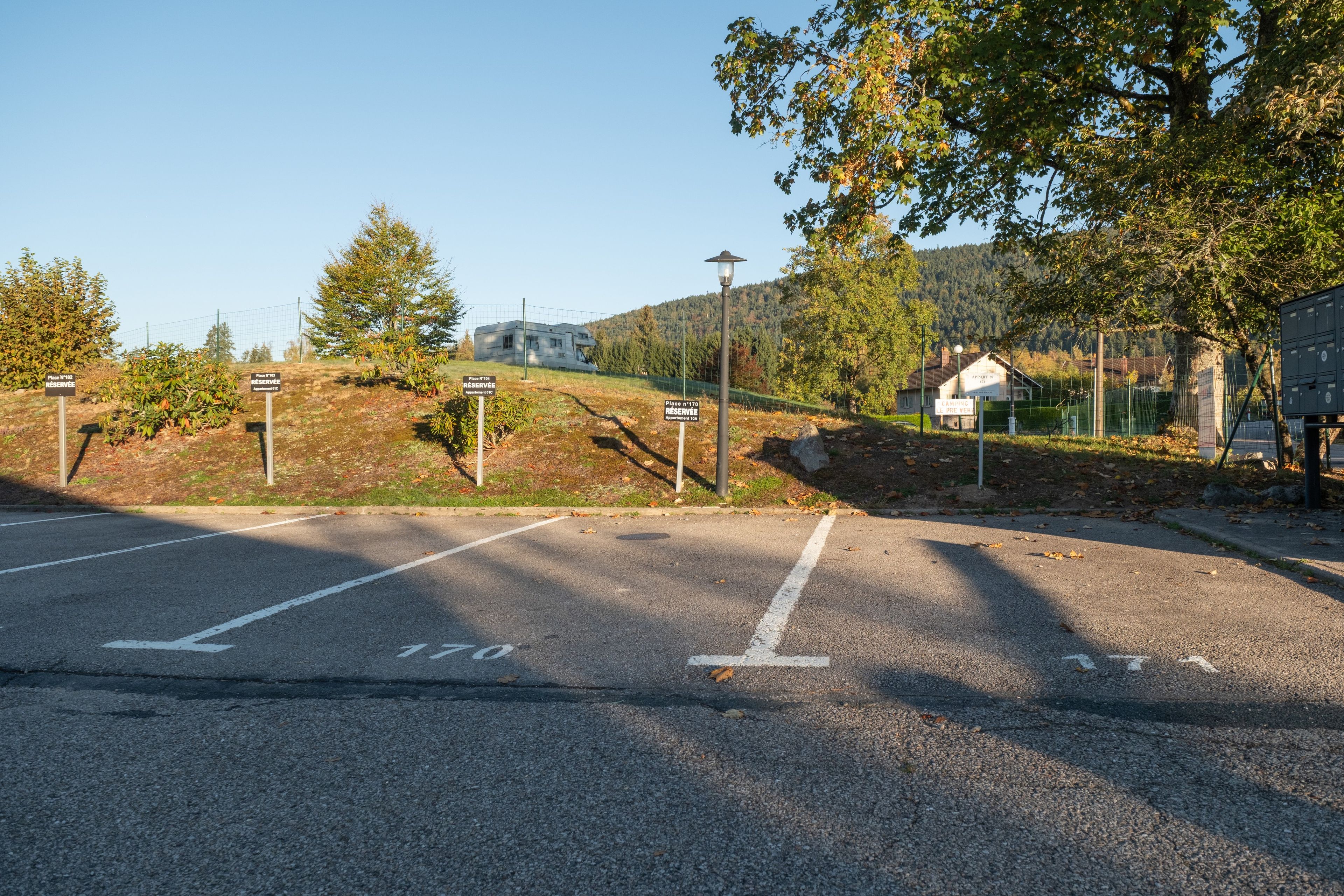 En parkeringsplads med afmærkede parkeringsbåse og piletavler.