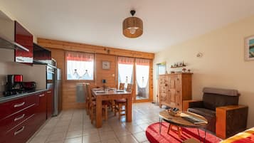 Un salon confortable avec une table à manger, des chaises, un canapé et un meuble pour la télévision.