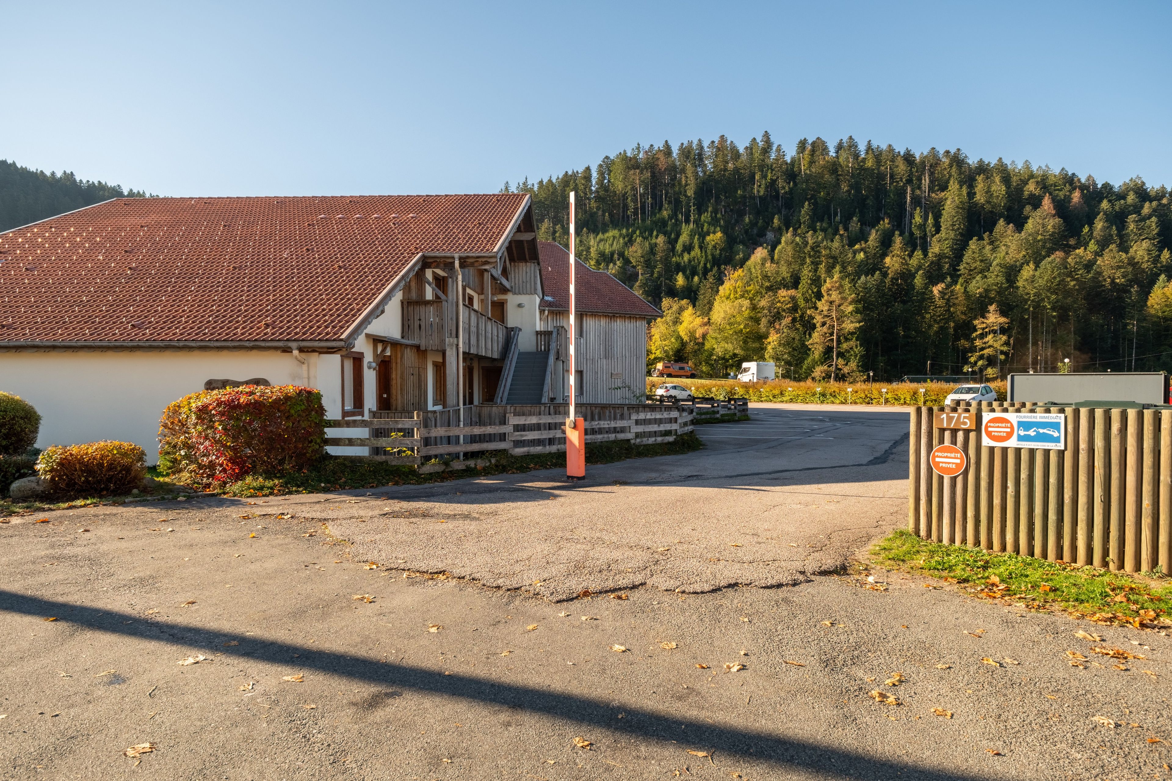 A building with a sloped roof, a wooden fence, and a sign indicating private property.