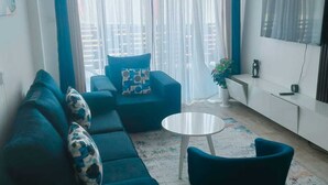Ein modernes Wohnzimmer mit einer Couch, einem Couchtisch und einem an der Wand befestigten Fernseher.