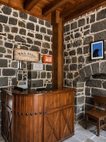 Un muro de piedra con un mostrador de recepción de madera y un cuadro enmarcado.