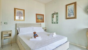 Una habitación de hotel con una cama, una mesita de noche y una pared decorada con tres cuadros.