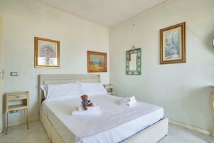 Una habitación de hotel con una cama, una mesita de noche y una pared decorada con tres cuadros.