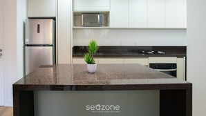 A modern kitchen with a granite countertop, stainless steel appliances, and a potted plant. - Apart 2 Bedrooms at Praia Brava in Itajai Rvc0702 (Itajai)