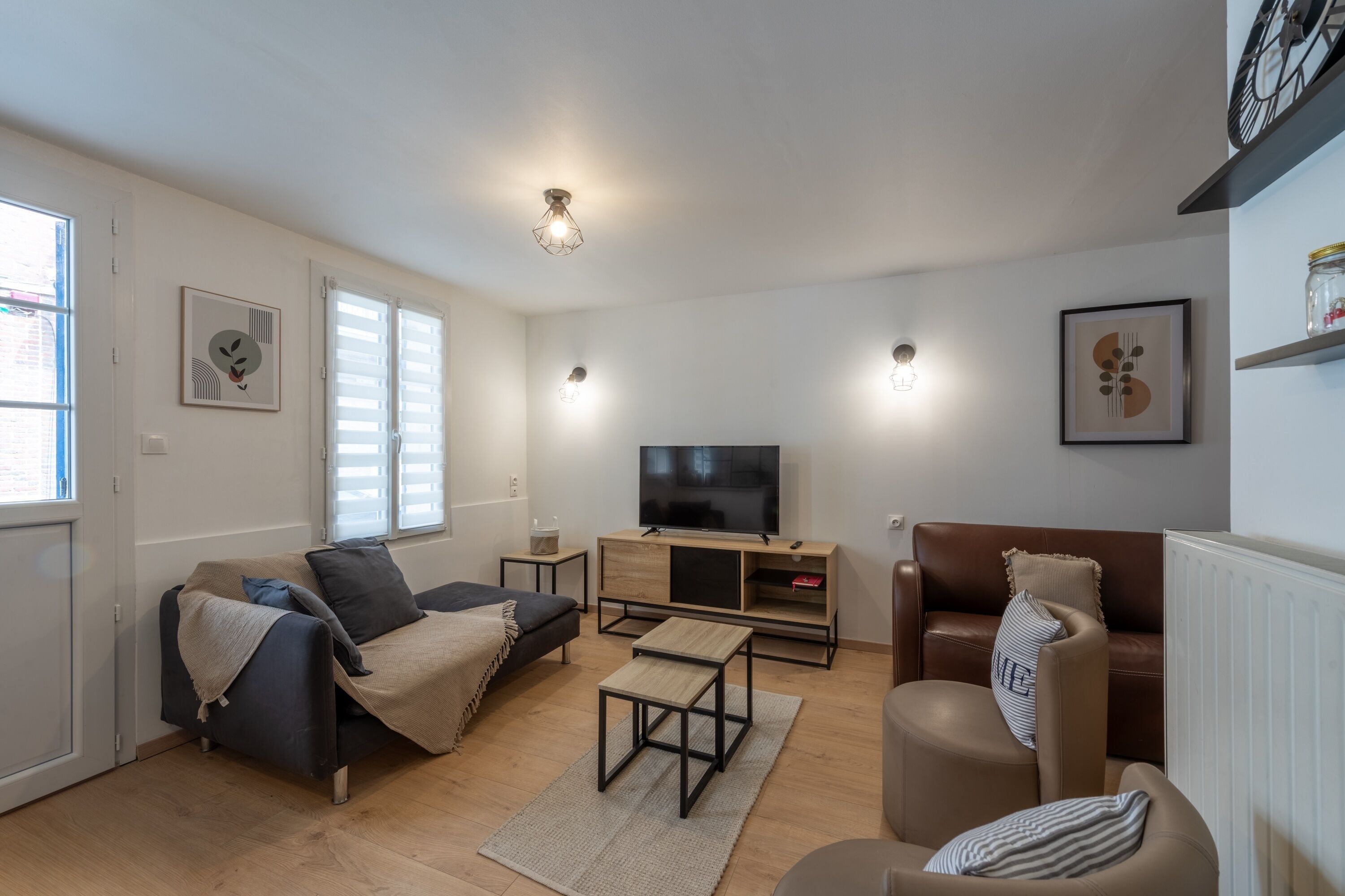Ein modernes Wohnzimmer mit einer Couch, einem Couchtisch, einem Fernseher und einem Kamin.