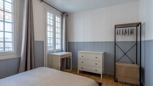 Ett sovrum med en säng, ett skrivbord, en byrå och en garderob.