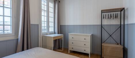 A bedroom with a bed, a desk, a dresser, and a wardrobe.