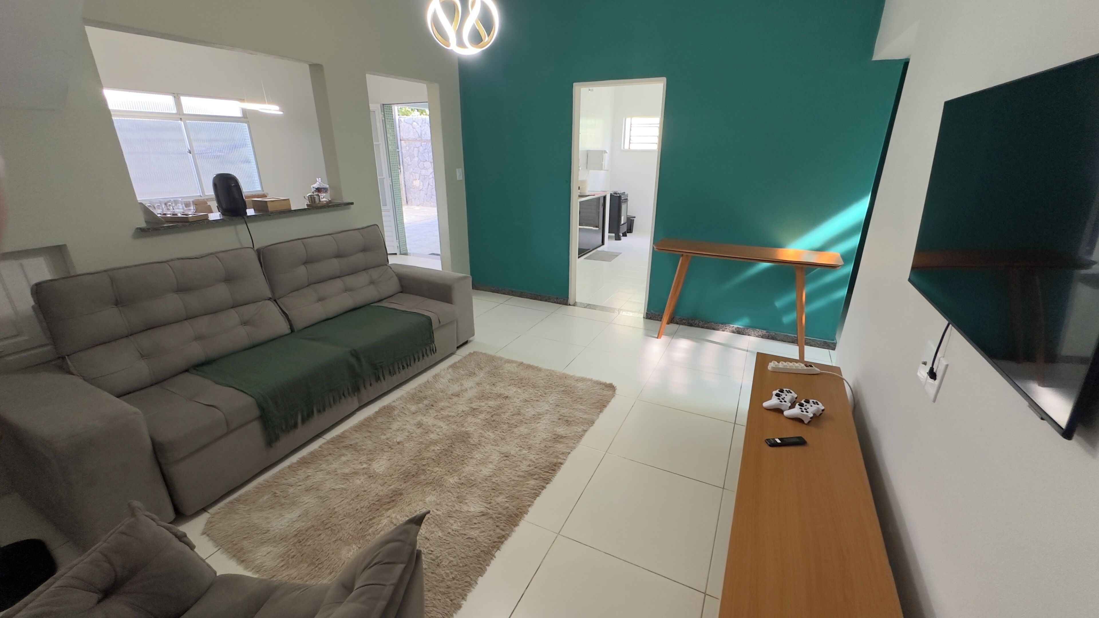 Ein modernes Wohnzimmer mit einer Couch, einem Couchtisch und einem Fernseher.