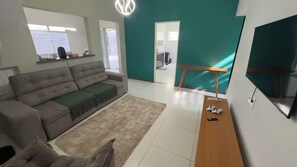 Un saló modern amb un sofà, una taula de centre i una televisió.