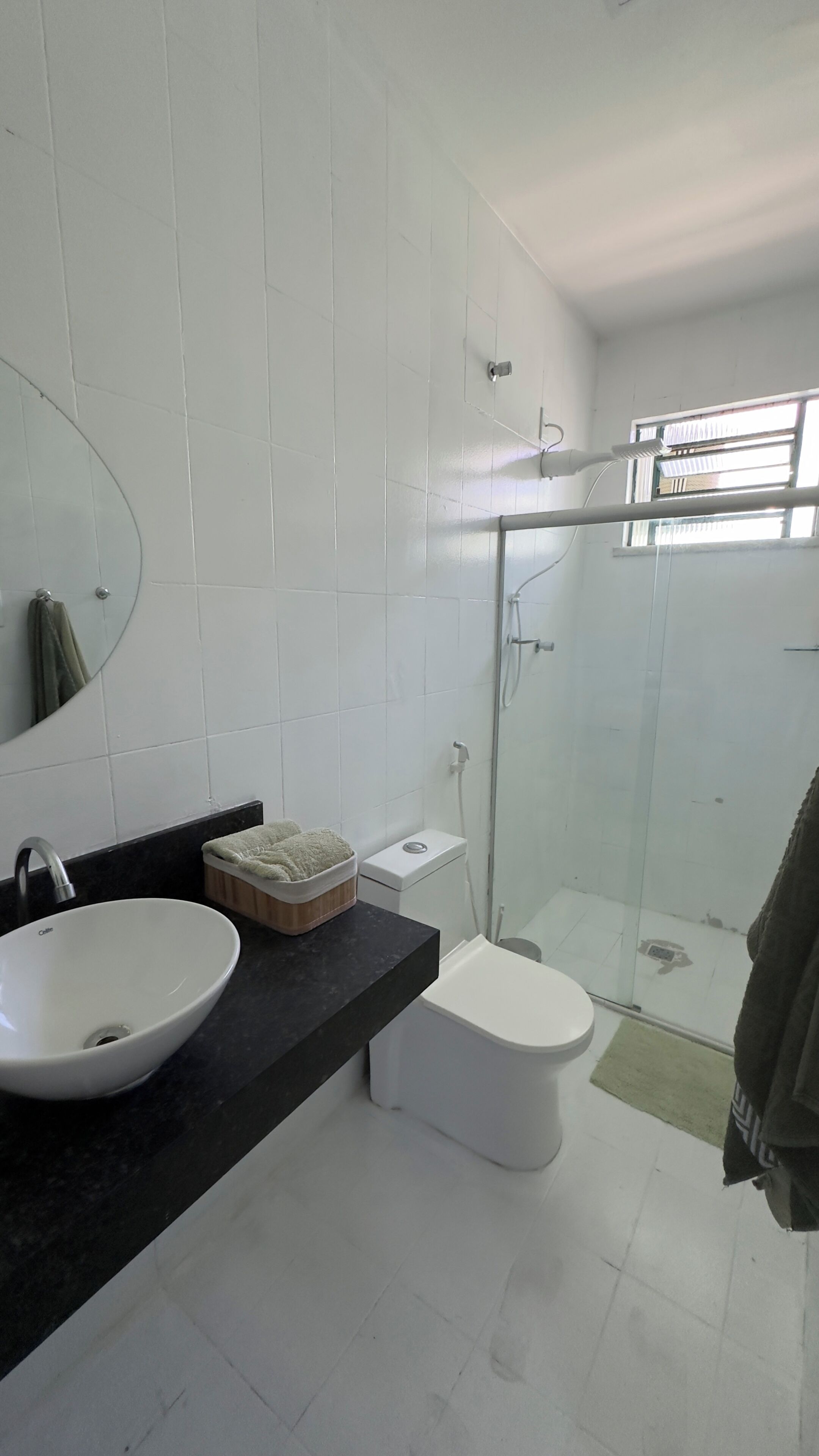 A modern bathroom with a white sink, toilet, and shower.