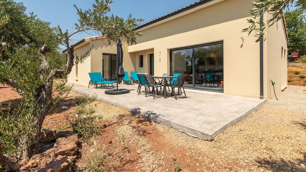 A modern building with a patio area featuring outdoor seating and a pergola. - Maison de la Seranne - Avec piscine (Le Bosc)