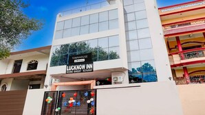 A multi-story building with a sign for 'Lucknow Inn' indicating it is a rooms, banquet, and restaurant establishment. - Classic Lucknow Inn (Lucknow)