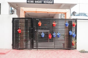 Ein begrenzter Zugang zu einem Gebäude, über dem ein Schild mit der Aufschrift 'ROOMS BANQUET RESTAURANT' angebracht ist.
