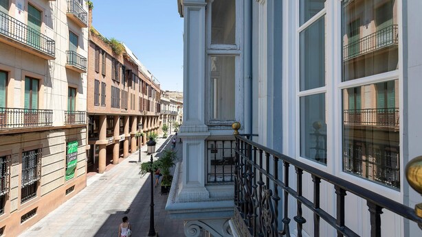Une vue de rue avec des bâtiments, un piéton et un escalier.