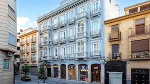 A multi-story building with a classic architectural style, featuring balconies and large windows. - Genteel Home San Anton 101 (Granada)