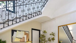 A spacious living area with a staircase, a fireplace, a sofa, a coffee table, and a potted plant. - Genteel Home San Anton 101 (Granada)