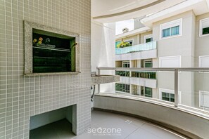 A modern apartment with a tiled wall, a window with a view of other buildings, and a balcony with a railing. - Apt in Building w/ Pool 350m From the Beach Rtg208 (Florianópolis)