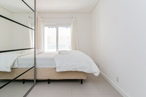 A bedroom with a bed, a window with curtains, and a mirror. - New apt With Barbecue 350m From the Beach Rtg101 (Florianópolis)